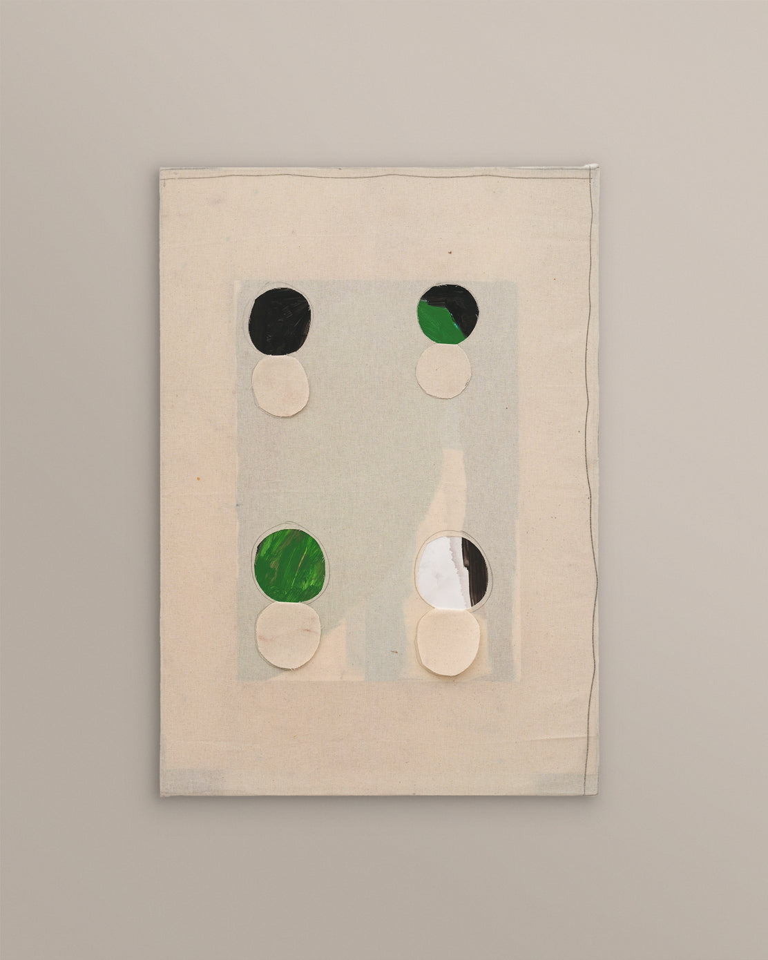 Textile art piece with circular patterns on a beige background